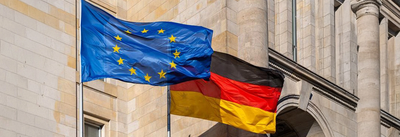 Die europäische und die deutsche Flagge wehen nebeneinander im Wind