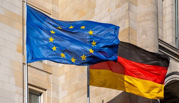 Die europäische und die deutsche Flagge wehen nebeneinander im Wind