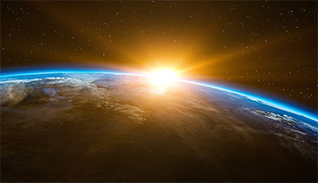Ein neuer Tag beginnt: Gleißendes Licht eines Sonnenaufgangs über der Erde aus dem All gesehen